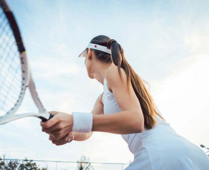 Woman giving return playing tennis on court