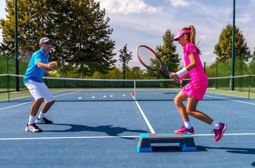 stock-photo-male-trainer-girl-tennis-training (4)